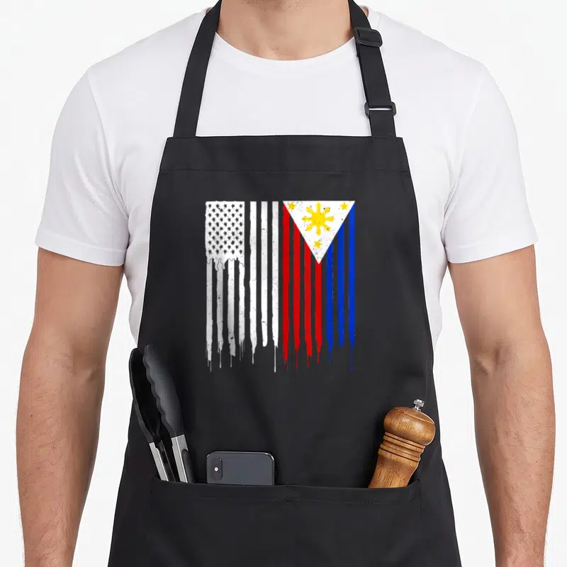 Cute filipino american flag apron - Merged US and Philippine flags with dripping paint, distressed red white blue yellow — shown on a black cotton canvas apron against a white background