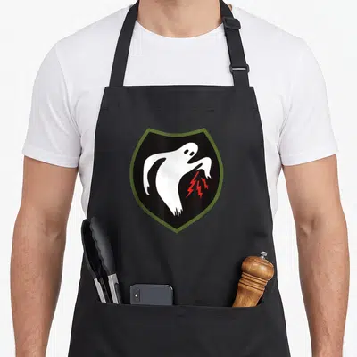 Ww2 special aprons - White ghost in black shield with olive green border and two red lightning bolts — shown on a black cotton canvas apron against a white background