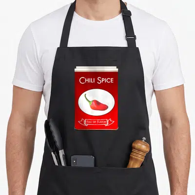 Chili spice apron - Red spice tin graphic with chili pepper and FULL OF FLAVOR text — shown on a black cotton canvas apron against a white background