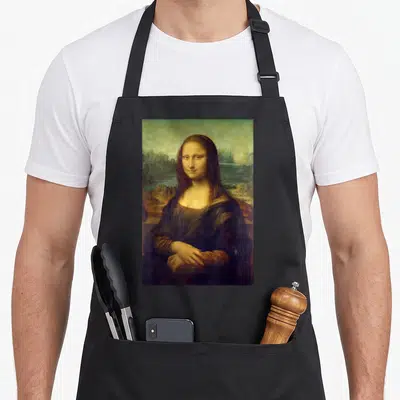 Mona teacher apron - Photo-style print of a woman and landscape in brown, green, and black on a black bib apron — shown on a black cotton canvas apron against a white background