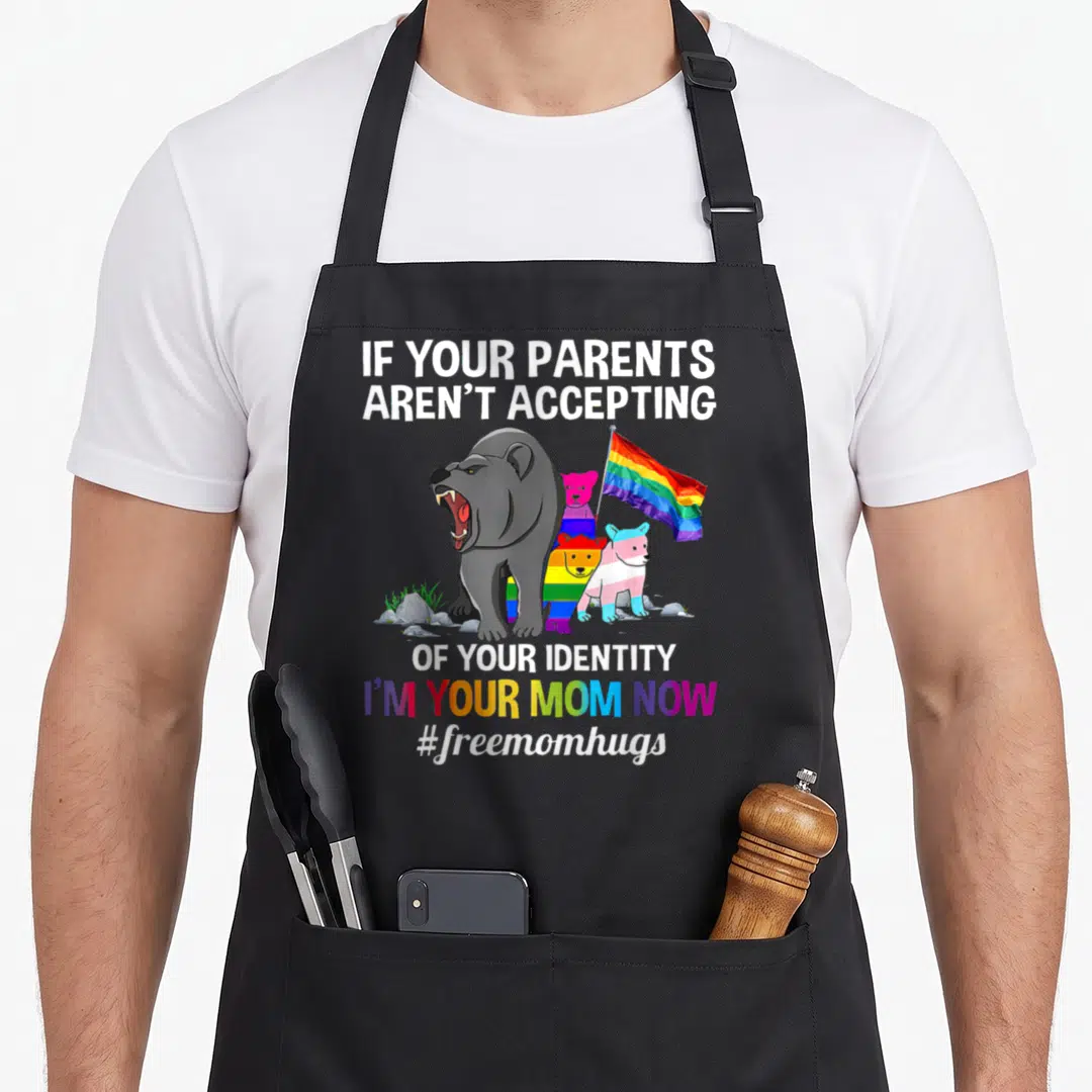 Parent bear mom apron - Four cartoon bears including a large grey one holding a rainbow flag under white and rainbow — shown on a black cotton canvas apron against a white background