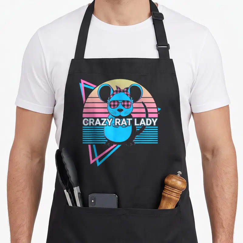 Funny mouse crazy rat lady apron - Blue rat with sunglasses and plaid bow in front of yellow pink striped circle — shown on a black cotton canvas apron against a white background