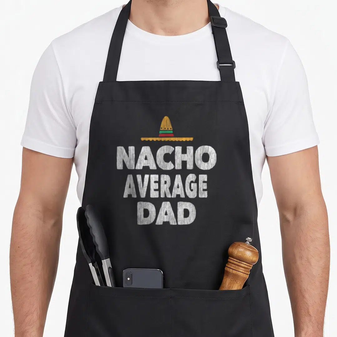 Nacho father day apron - Yellow sombrero above white distressed NACHO AVERAGE DAD text — shown on a black cotton canvas apron against a white background