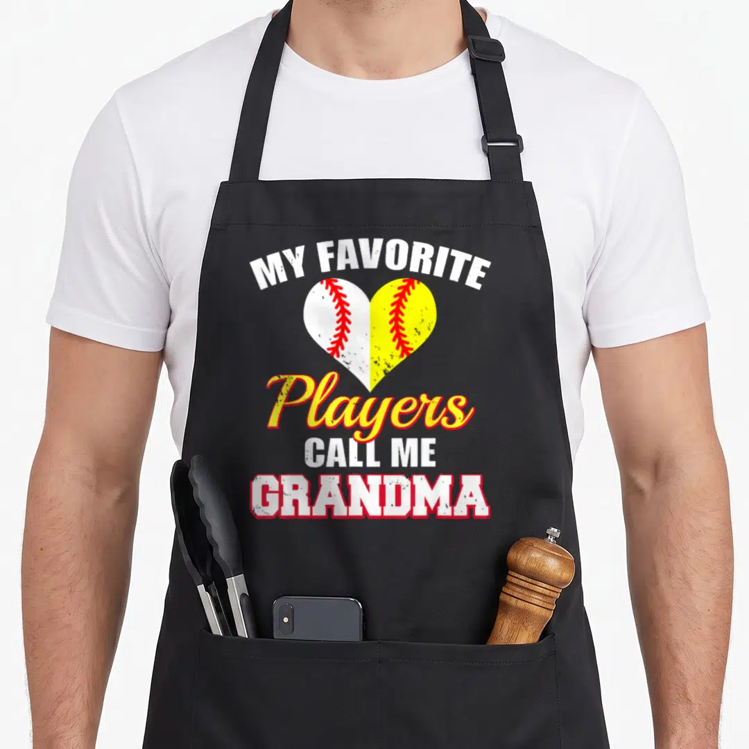 Baseball softball grandma apron - Split heart baseball softball graphic with MY FAVORITE Players CALL ME GRANDMA text — shown on a black cotton canvas apron against a white background