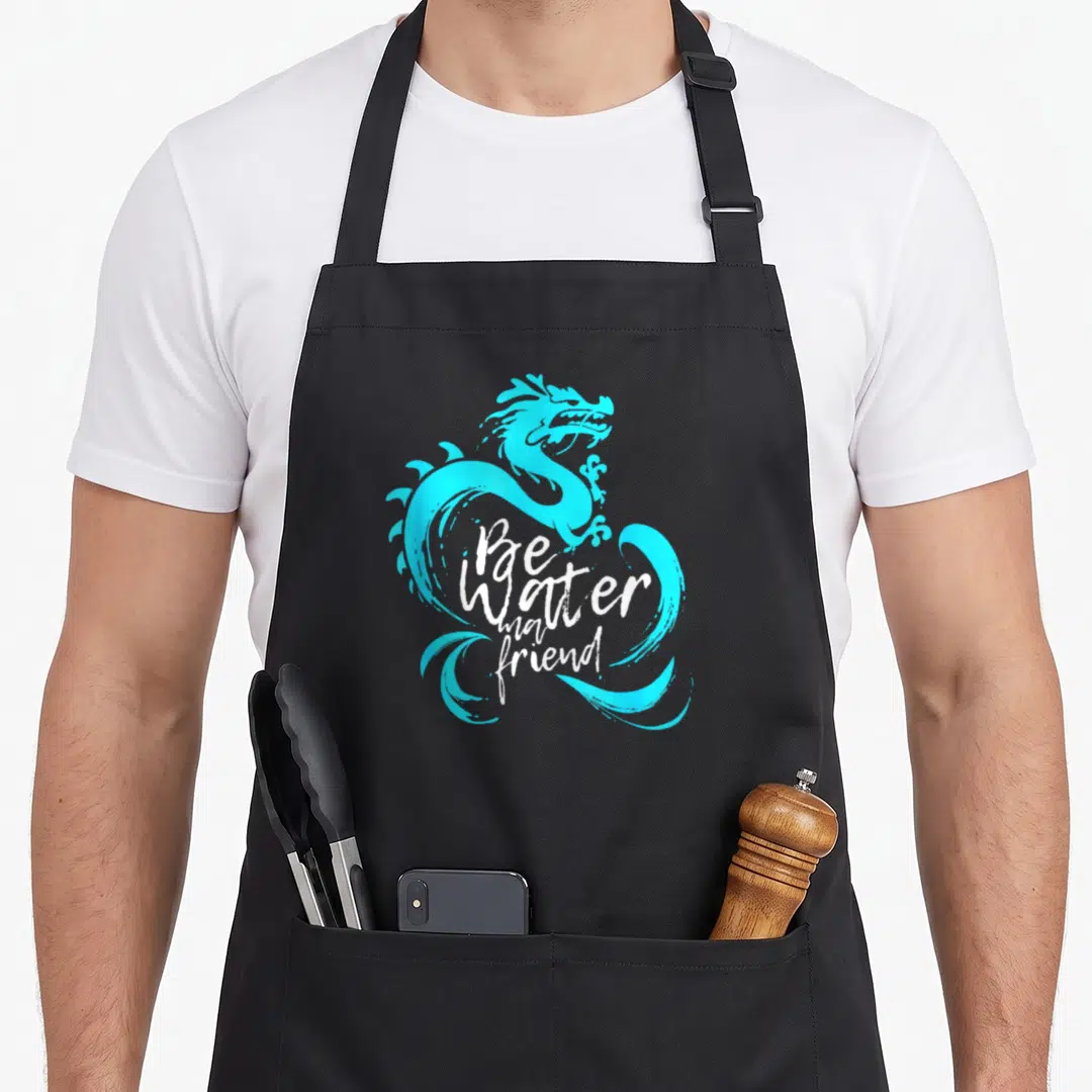 Water friends apron - Cyan dragon coiled around white Be Water my friend script text — shown on a black cotton canvas apron against a white background