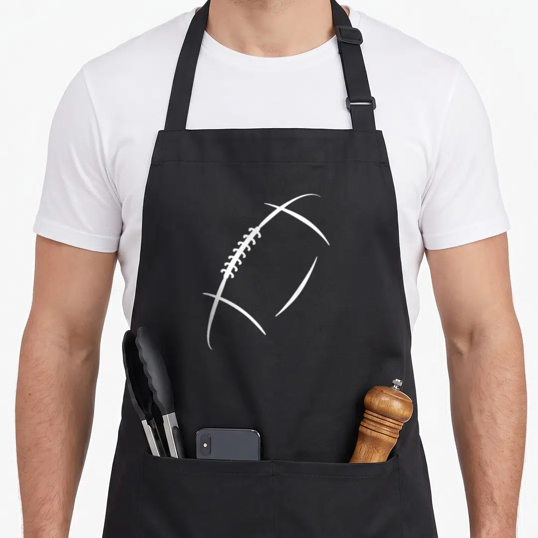 Gear football apron - White outline of an American football with laces on a grey background — shown on a black cotton canvas apron against a white background