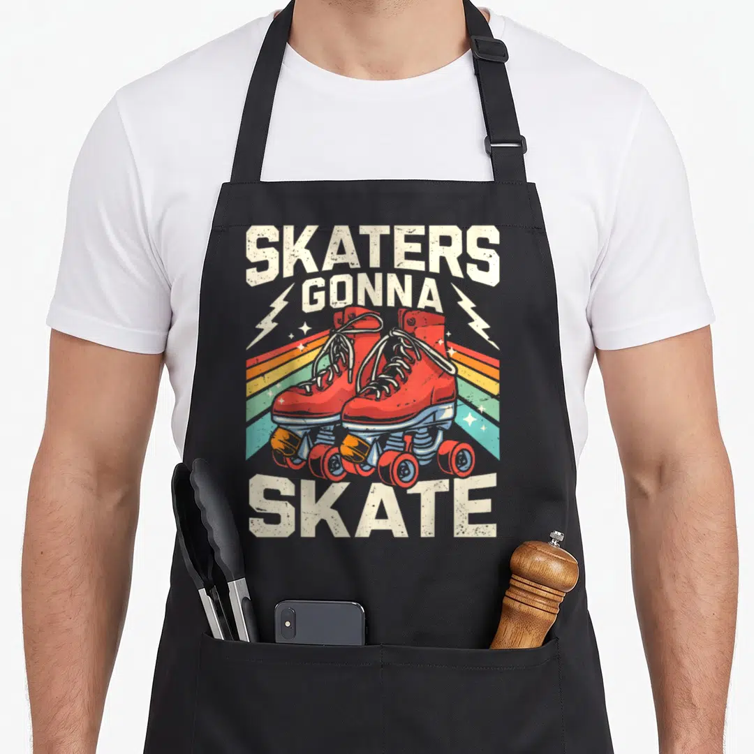 Skating skater 70s apron - Red roller skates over rainbow stripes with SKATERS GONNA SKATE text and lightning bolts — shown on a black cotton canvas apron against a white background