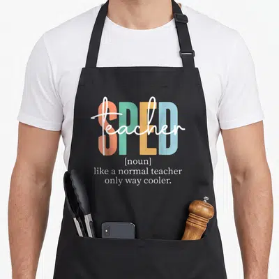 Sped definition personalized teacher aprons - Stacked colorful text reading SPED teacher noun like a normal teacher — shown on a black cotton canvas apron against a white background