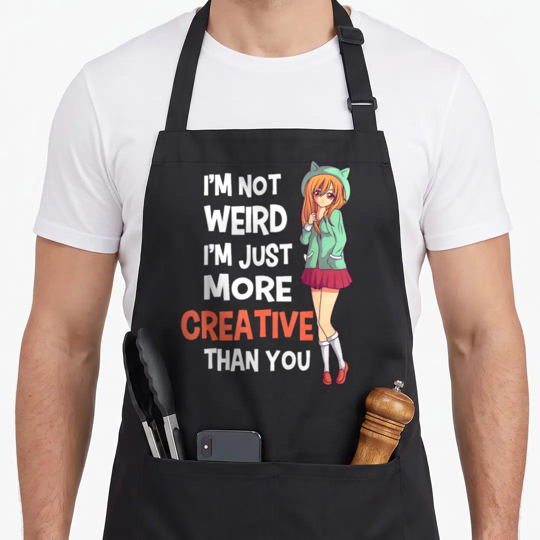 Manga creative apron - Stacked text I'm Not Weird I'm Just More Creative Than You beside anime girl in mint hat — shown on a black cotton canvas apron against a white background