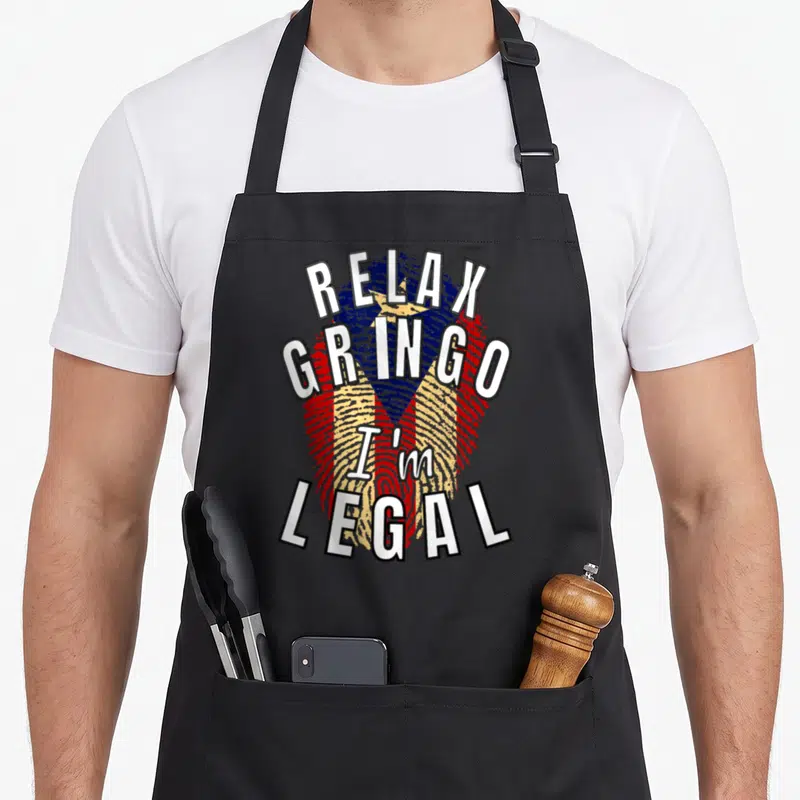 Relax paper apron - Fingerprint filled with red white and blue flag stripes overlaid with text reading Relax Gringo I'm — shown on a black cotton canvas apron against a white background