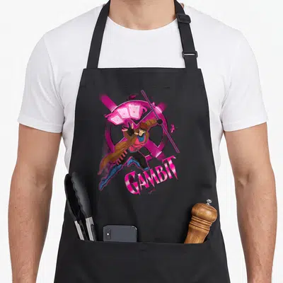 Throwing x apron - Gambit leaping with playing cards and X logo in pink purple brown blue cartoon style — shown on a black cotton canvas apron against a white background