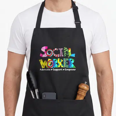 Appreciation social worker apron - Colorful stacked SOCIAL WORKER text with Advocate Support Empower in white hearts — shown on a black cotton canvas apron against a white background