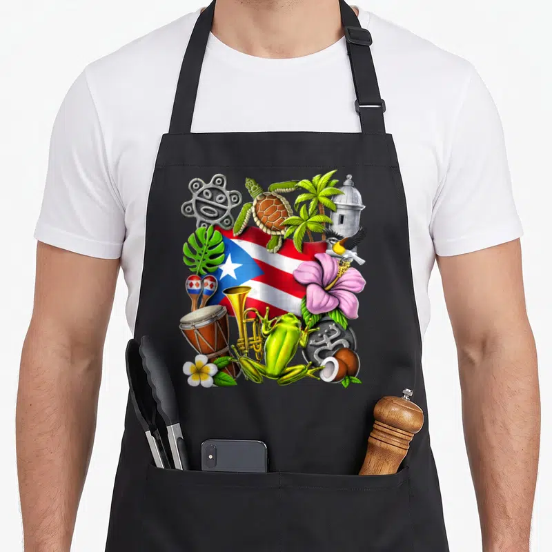 Taino frog aprons - Waving flag, coqui frog, Taino petroglyph, maracas, hibiscus, turtle, trumpet — shown on a black cotton canvas apron against a white background