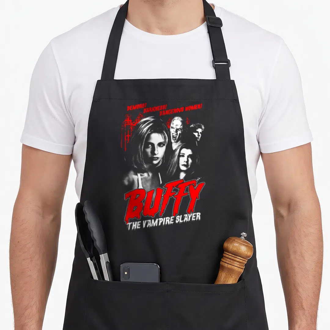 Buffy horror apron - Red DEMONS text above four grayscale portraits and large BUFFY title — shown on a black cotton canvas apron against a white background