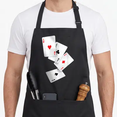 Four pro apron - Four realistic ace cards scattered diagonally in white, red, and black — shown on a black cotton canvas apron against a white background