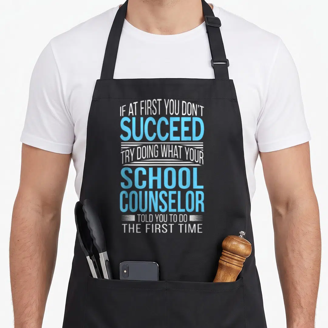 School child expires apron - White and blue stacked text reading If at first you don't succeed try doing what your — shown on a black cotton canvas apron against a white background