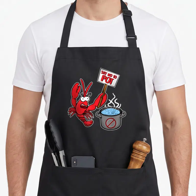 Funny pot lobster apron - Angry red cartoon lobster holding SAY NO TO POT sign next to steaming grey pot with blue — shown on a black cotton canvas apron against a white background