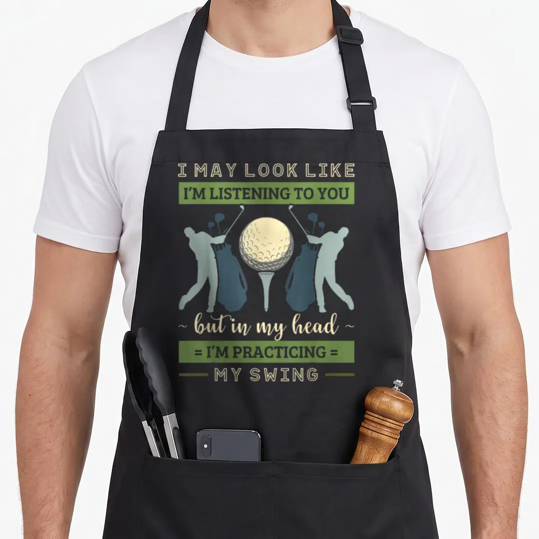 May eagles apron - Golf ball on tee flanked by two mirrored golfer silhouettes with stacked humorous text about — shown on a black cotton canvas apron against a white background