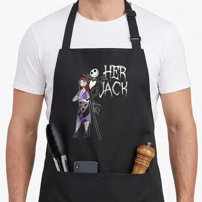 Cute jack apron - Jack Skellington and Sally standing together next to stacked HER JACK text in cartoon style — shown on a black cotton canvas apron against a white background