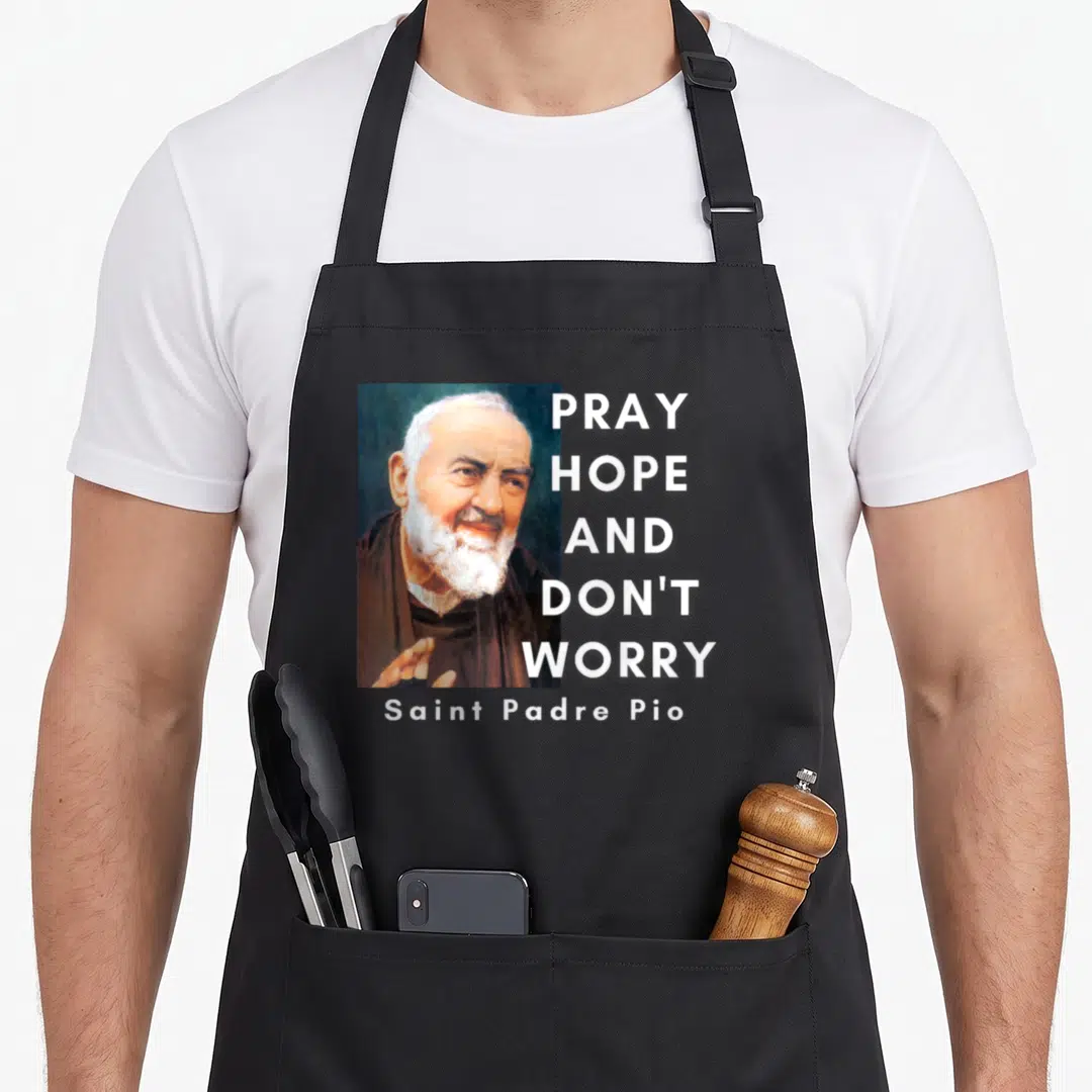 Pio catholic apron - Portrait of Padre Pio with stacked Pray Hope Don't Worry text in white brown and blue — shown on a black cotton canvas apron against a white background