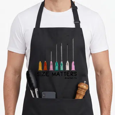 Come nurse apron - Seven increasing size needles above SIZE MATTERS text in black, pink, teal, orange, silver — shown on a black cotton canvas apron against a white background