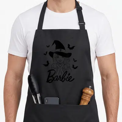 Bat halloween witch apron - Black line-art of Barbie as a witch with scattered bats and 'Barbie' script below — shown on a black cotton canvas apron against a white background