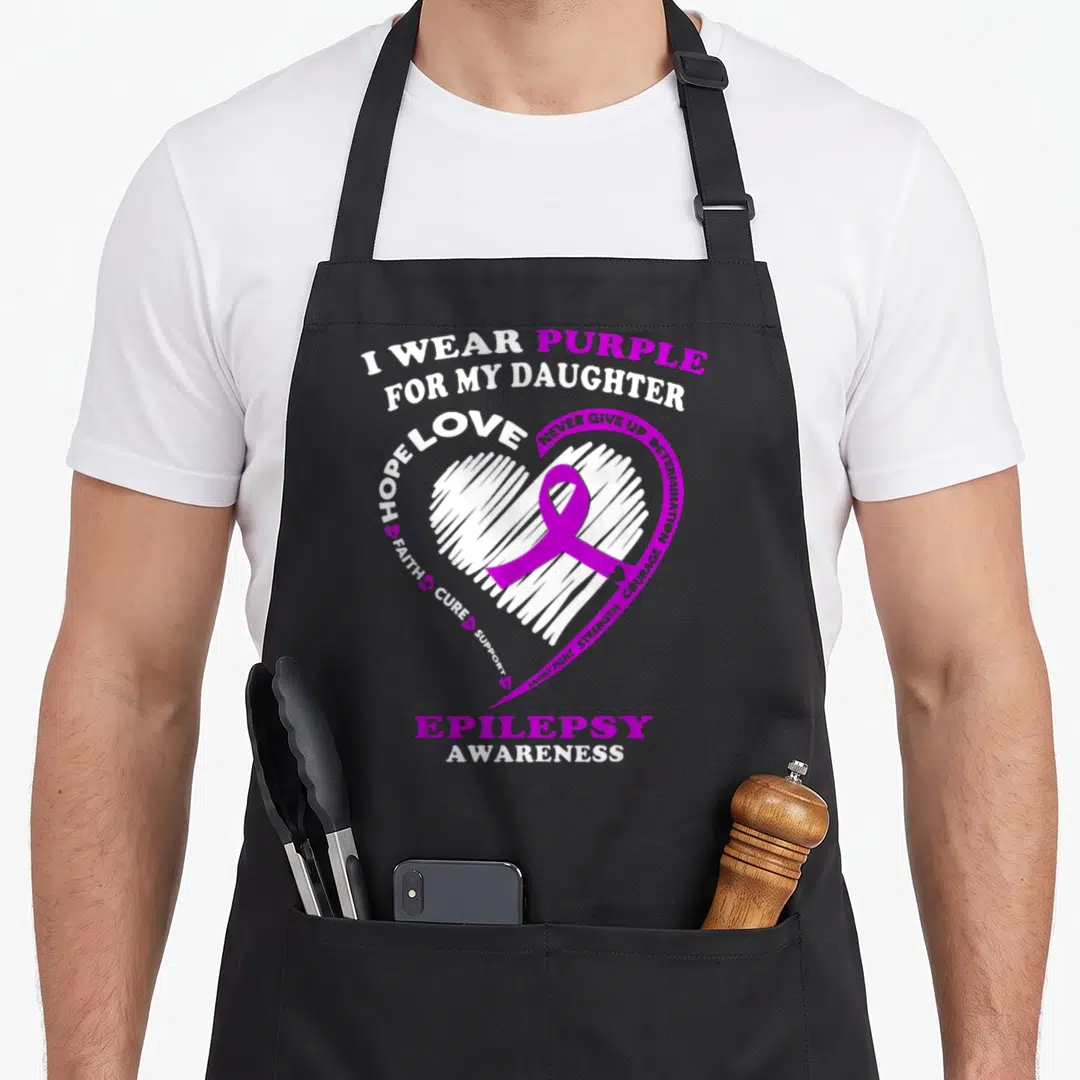 Daughter epilepsy awareness apron - White scribbled heart with purple ribbon and epilepsy awareness text — shown on a black cotton canvas apron against a white background