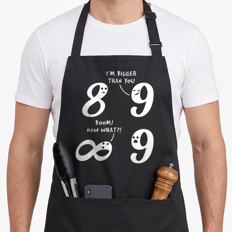 Mathematic joke bbq aprons - White numbers 8 and 9 with speech bubbles and infinity symbol in two comic scenes — shown on a black cotton canvas apron against a white background