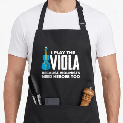 Play musical apron - Blue viola graphic beside white text reading I play the viola because violinists need heroes too — shown on a black cotton canvas apron against a white background