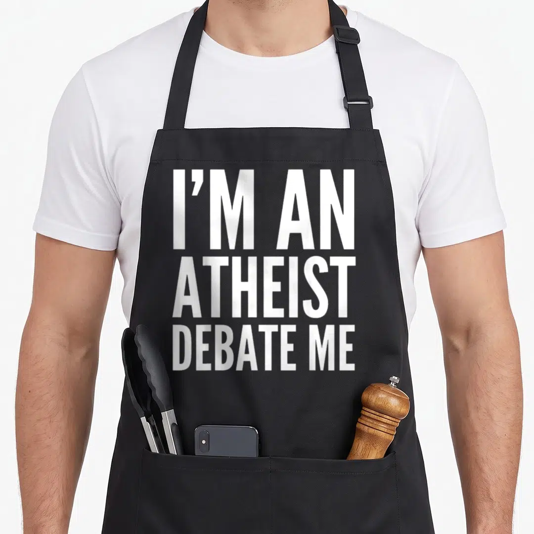Atheist adult birthday apron - White stacked text reading I'M AN ATHEIST DEBATE ME on black fabric — shown on a black cotton canvas apron against a white background
