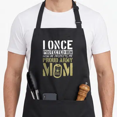 Proud army mom apron - Distressed text I once protected him now he protects me with tan dog tag replacing the O in mom — shown on a black cotton canvas apron against a white background