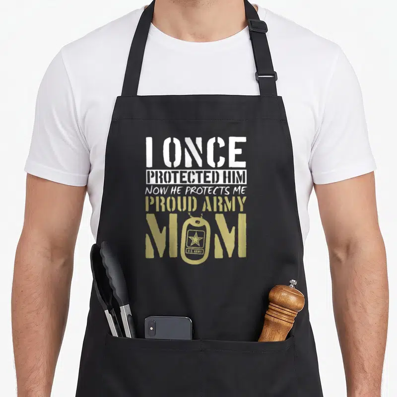 Proud army mom apron - Distressed text I once protected him now he protects me with tan dog tag replacing the O in mom — shown on a black cotton canvas apron against a white background