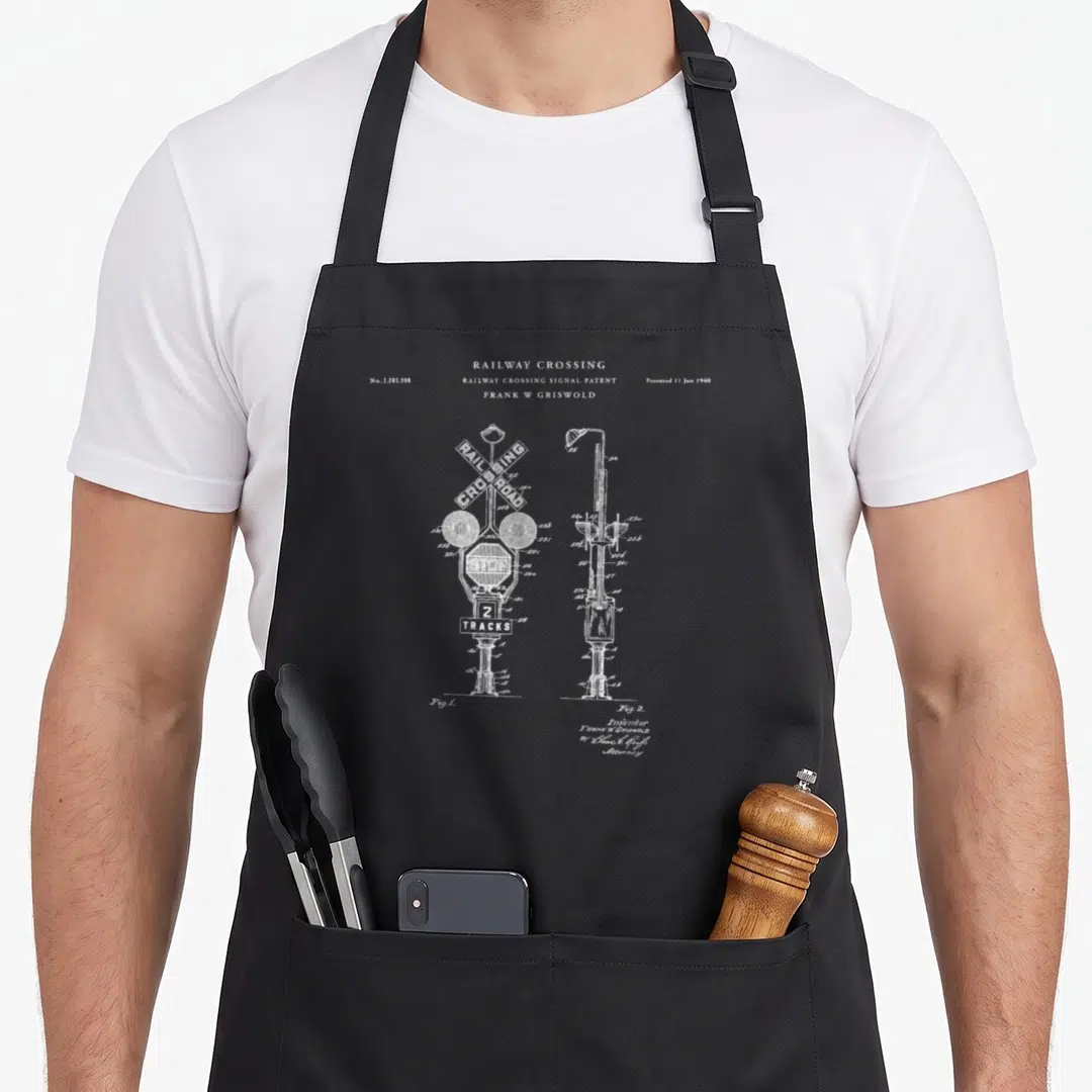Crossing railroad train apron - White line art of railway crossing signal patent No 2203598 with two figures — shown on a black cotton canvas apron against a white background
