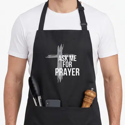Ask service apron - White ASK ME FOR PRAYER text over a distressed grey cross on black fabric — shown on a black cotton canvas apron against a white background