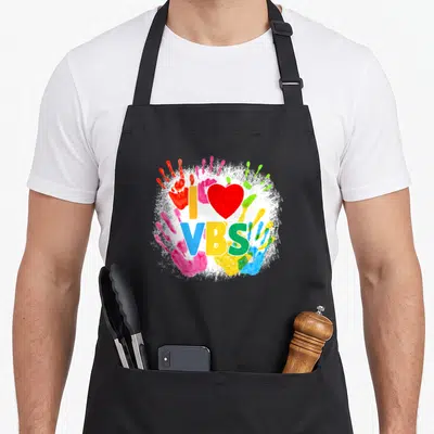 School handprint apron - I VBS text with red heart and colorful handprints on white splatter background — shown on a black cotton canvas apron against a white background