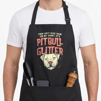 Pitbull glitter dog apron - Stacked text about pitbull glitter above a white pitbull head with small stars — shown on a black cotton canvas apron against a white background