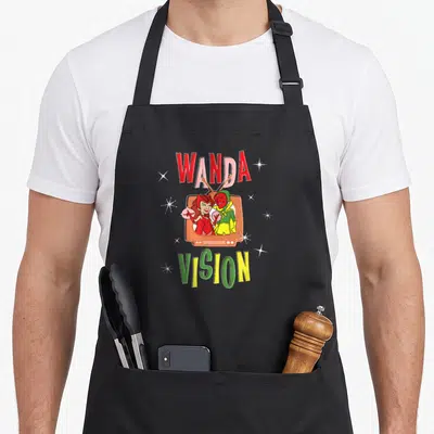 Wanda artwork apron - Retro TV illustration with Wanda Vision text and starbursts — shown on a black cotton canvas apron against a white background