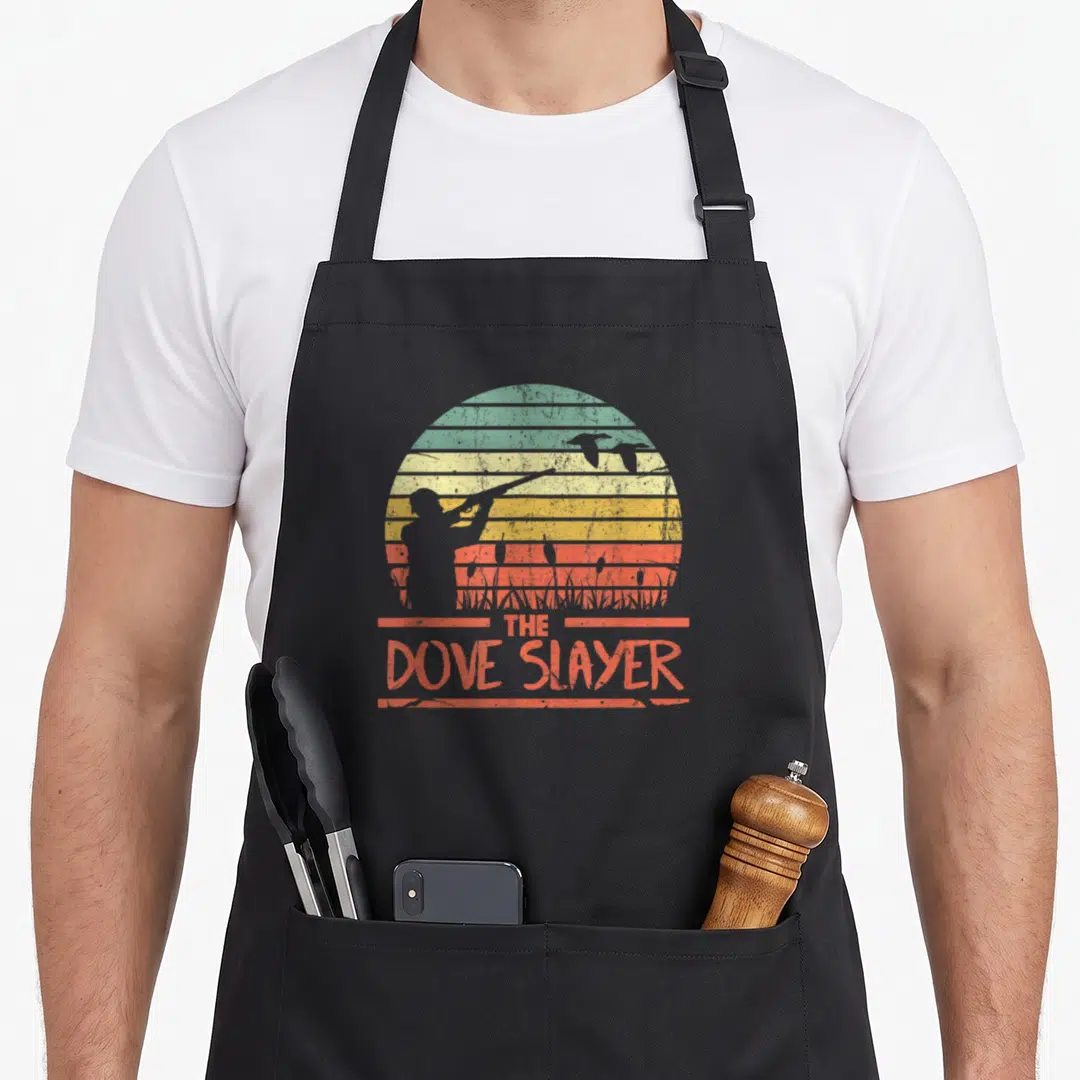 Hunt funny dove hunting apron - Retro hunter silhouette with shotgun against striped sun and flying birds above — shown on a black cotton canvas apron against a white background