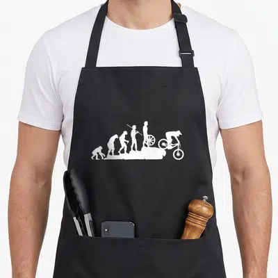 Evolution bike apron - Six white silhouettes showing human evolution ending with a mountain biker riding downhill — shown on a black cotton canvas apron against a white background