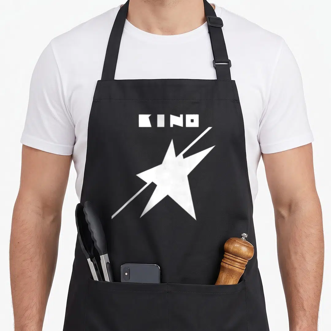 Wiktor russia apron - White KINO text above a star with a diagonal slash — shown on a black cotton canvas apron against a white background