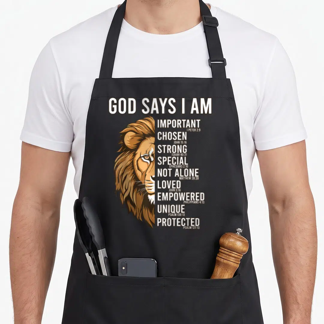 Christian god says i am apron - Realistic lion face beside vertical list of words IMPORTANT STRONG LOVED PROTECTED — shown on a black cotton canvas apron against a white background