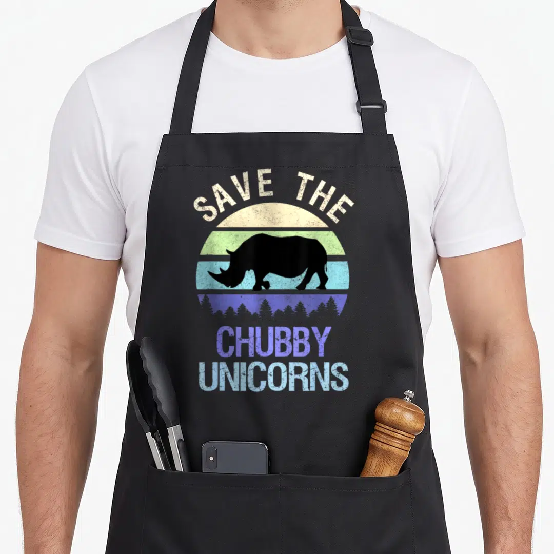 Sunset unicorn apron - Black rhino silhouette in front of striped beige green blue purple sun with SAVE THE CHUBBY — shown on a black cotton canvas apron against a white background