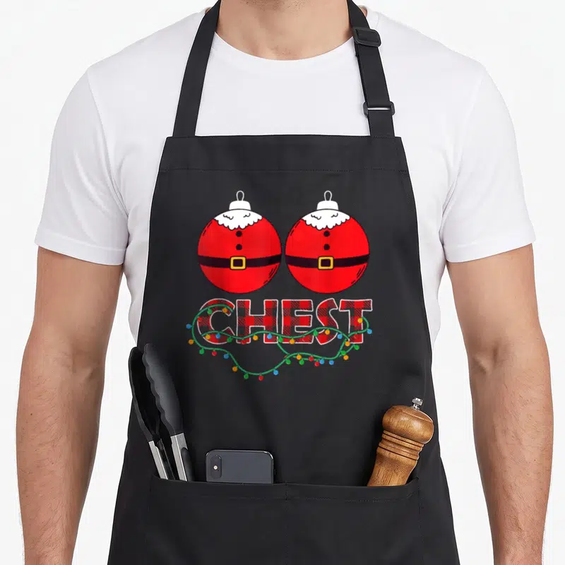 Chestnut chest couples christmas aprons - Two red Santa ornaments above plaid CHEST text wrapped in colorful string — shown on a black cotton canvas apron against a white background