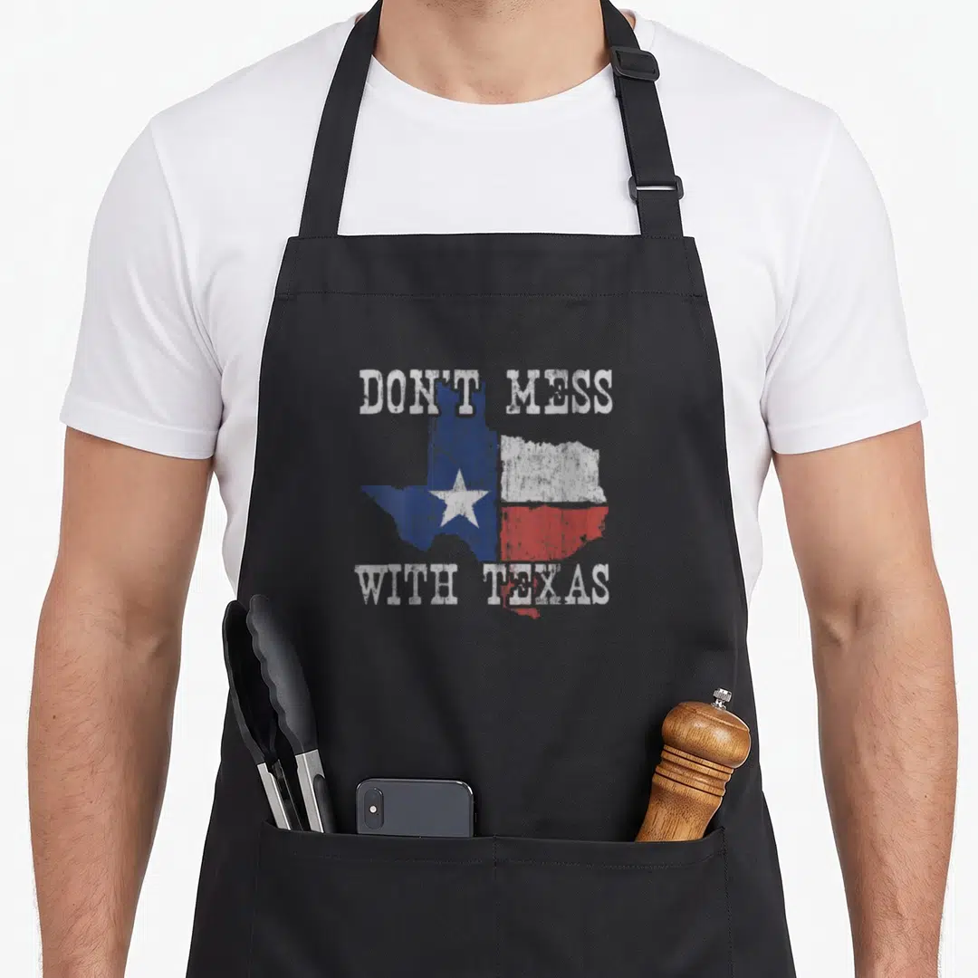 Lone texas longhorn apron - Distressed Texas map with Don't Mess With Texas text in blue white red — shown on a black cotton canvas apron against a white background