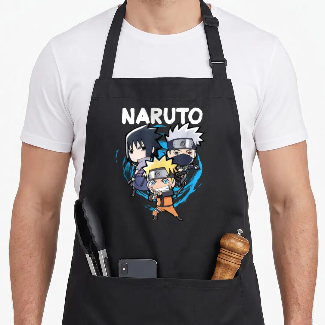 Chibi novelty apron - NARUTO text above three chibi ninjas in orange and blue cartoon style — shown on a black cotton canvas apron against a white background