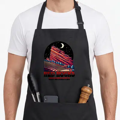 Amphitheater morrisons apron - Retro circular print of red rock formation, moon, stars, and tiered seating with stacked — shown on a black cotton canvas apron against a white background