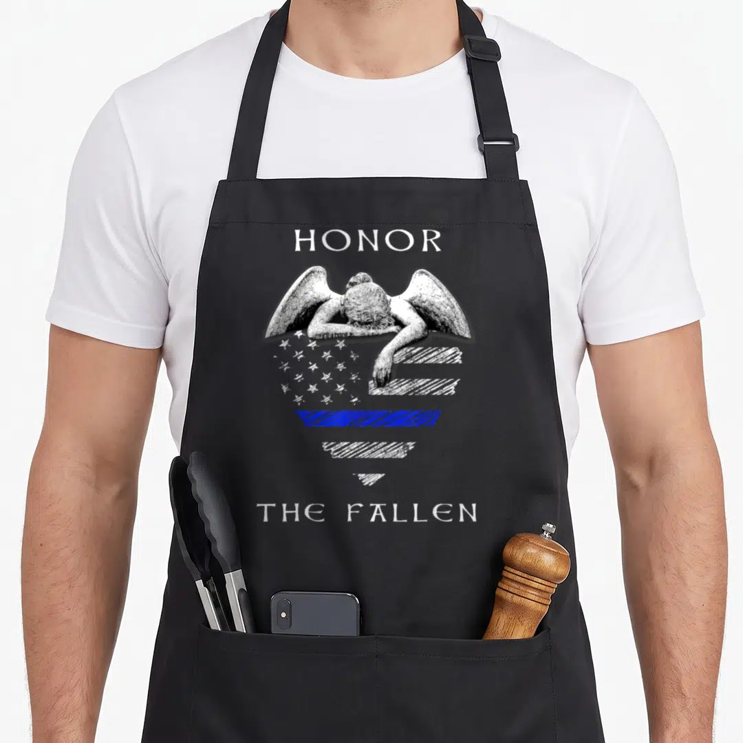 Fallen police apron - Angel leaning over heart shaped thin blue line flag with Honor The Fallen text — shown on a black cotton canvas apron against a white background
