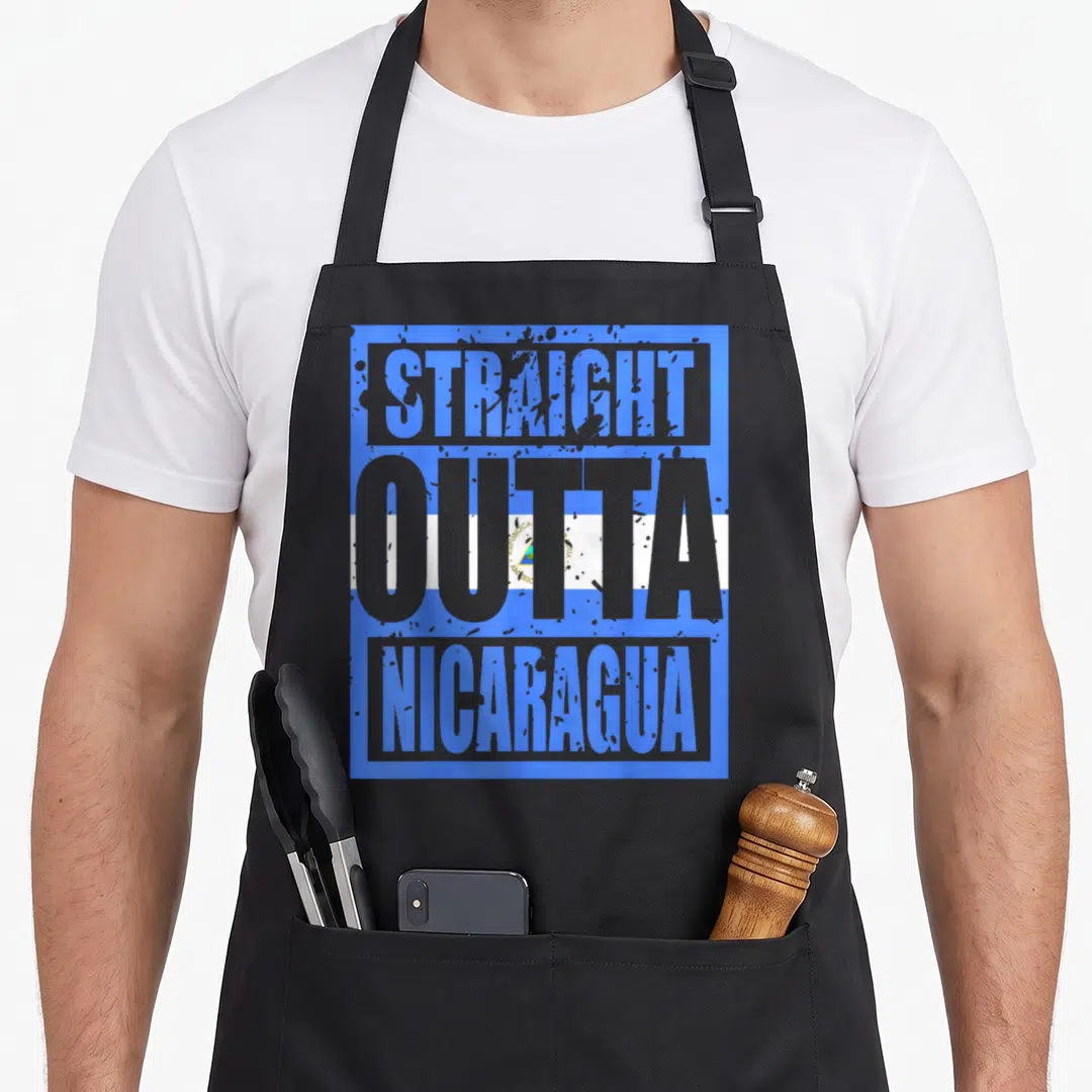Straight nicaragua apron - STRAIGHT OUTTA NICARAGUA text in grey and blue over a rectangular flag background — shown on a black cotton canvas apron against a white background