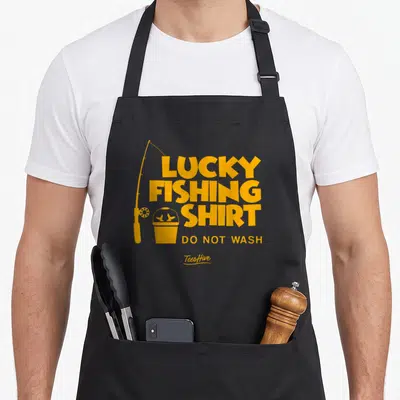 Lucky fishing aprons - Yellow lucky fishing shirt do not wash text with rod and fish bucket icon — shown on a black cotton canvas apron against a white background