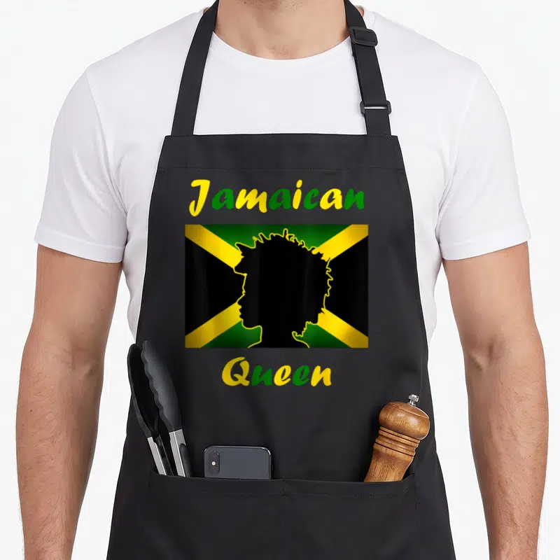 Jamaica queen apron - Jamaican Queen text over black female silhouette on green yellow and black flag — shown on a black cotton canvas apron against a white background
